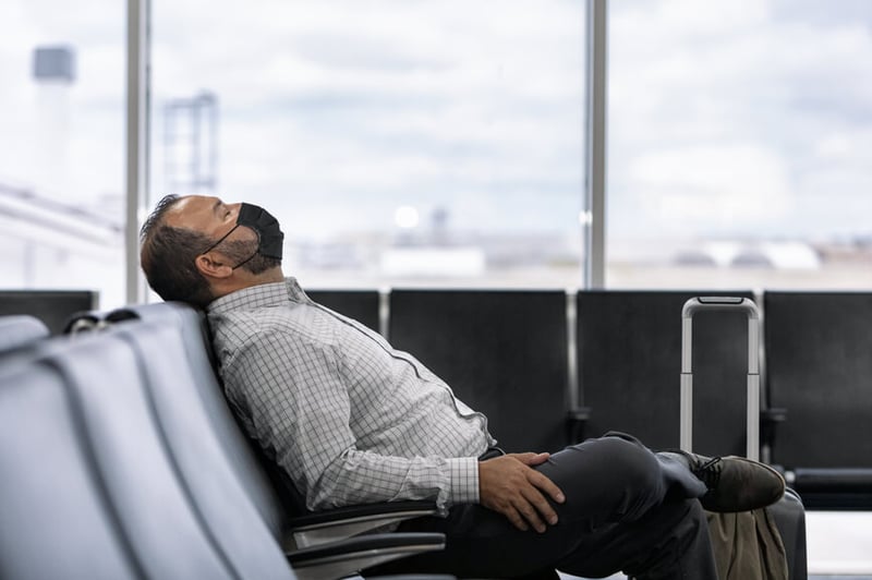 tired-traveler-sleeping-in-airport-how-to-fix-sleep-schedule